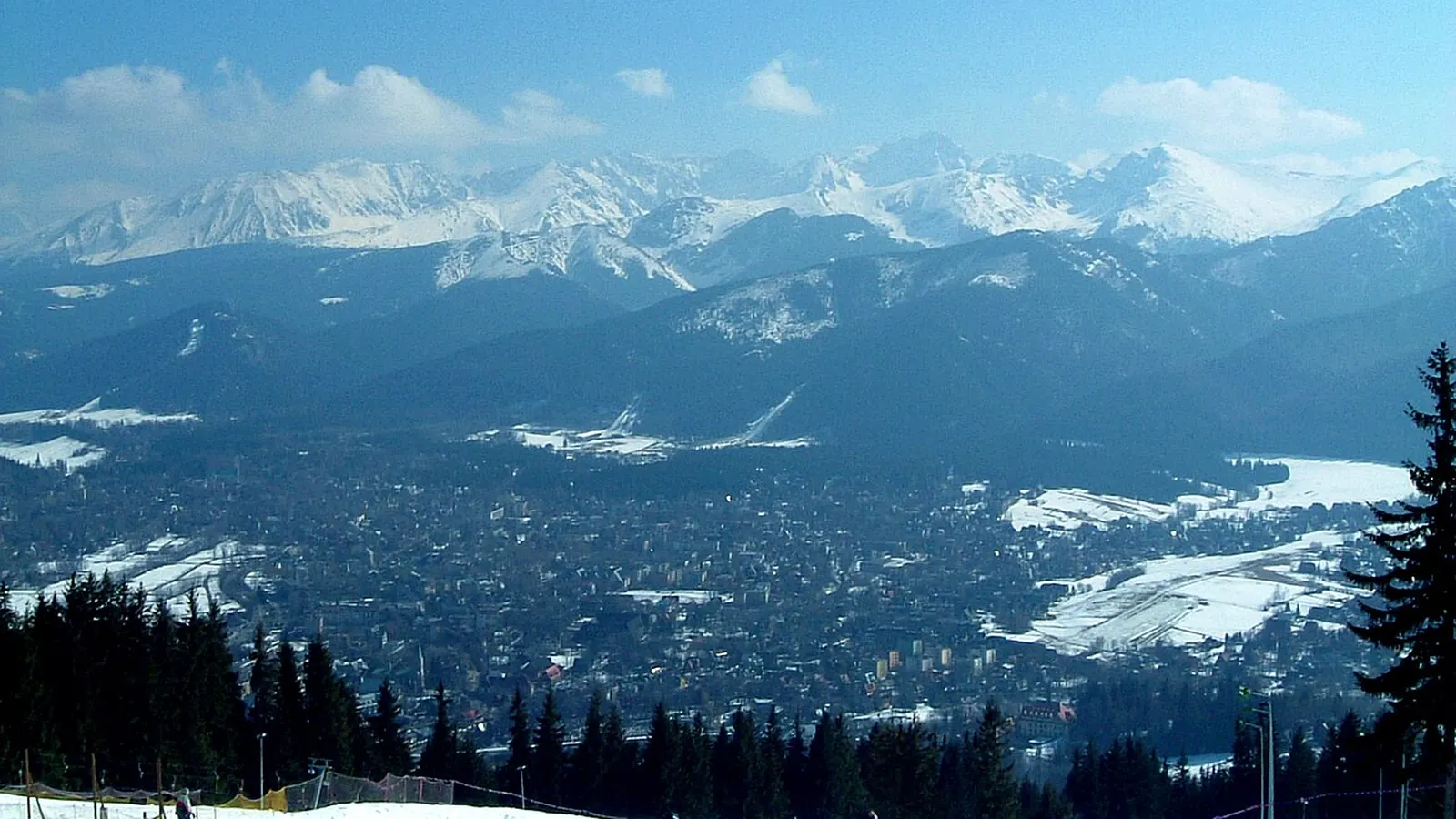 Zakopane i ośnieżone Tatry widziane z Gubałówki zimą, na pierwszym planie stok