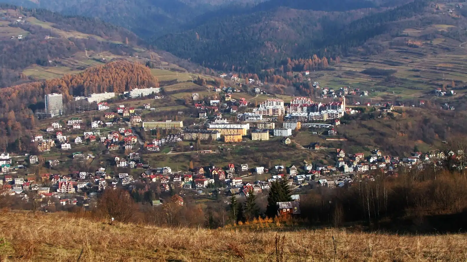 Zabudowa Szczawnicy w dolinie, w tle pasma Beskidu Sądeckiego w jesiennych barwach