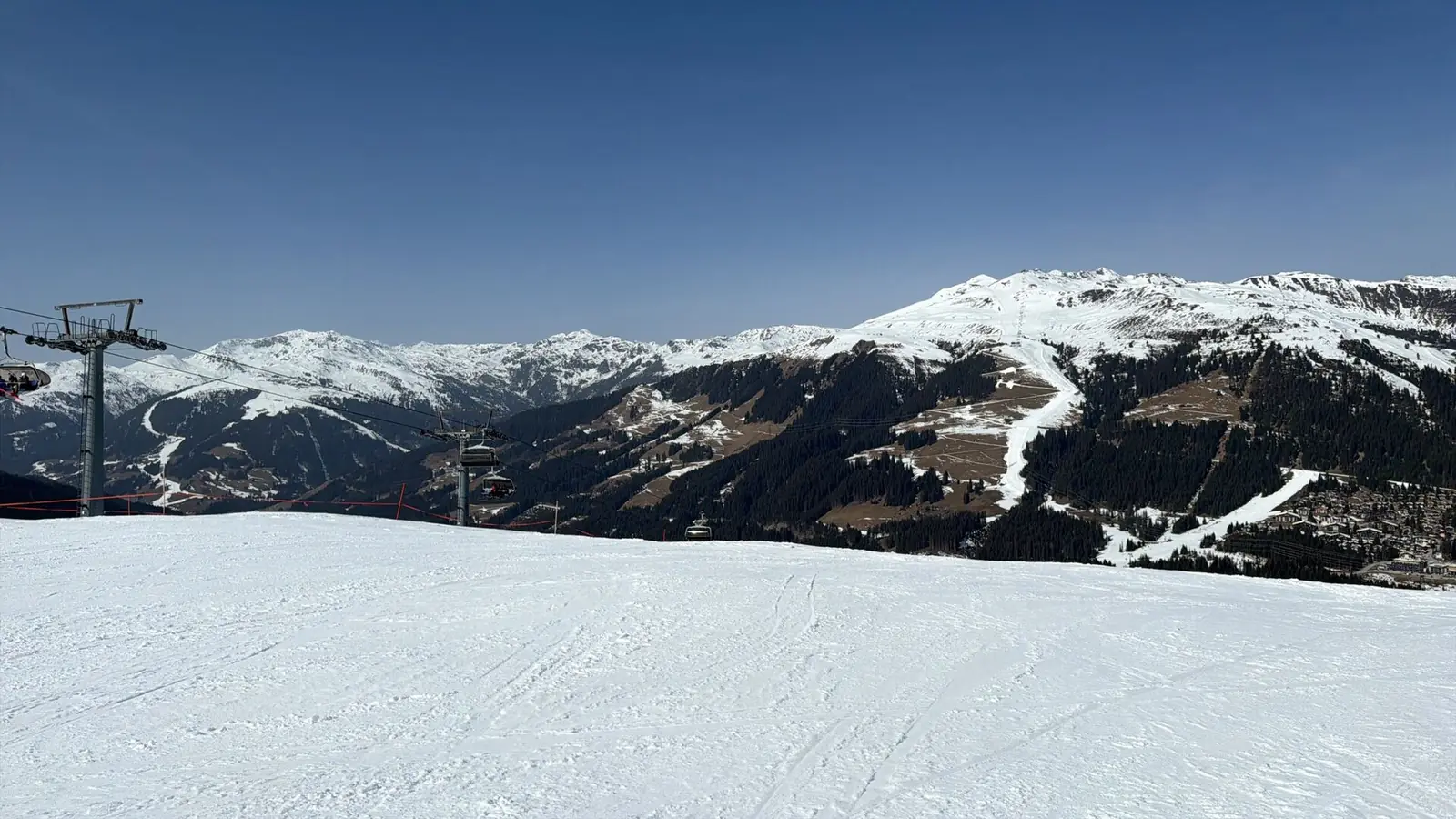 Szeroki ośnieżony stok w Zillertal Arena, w tle zaśnieżone grzbiety i zalesiona dolina